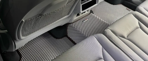 Light-coloured EVA mats fitted in the rear of a premium car interior