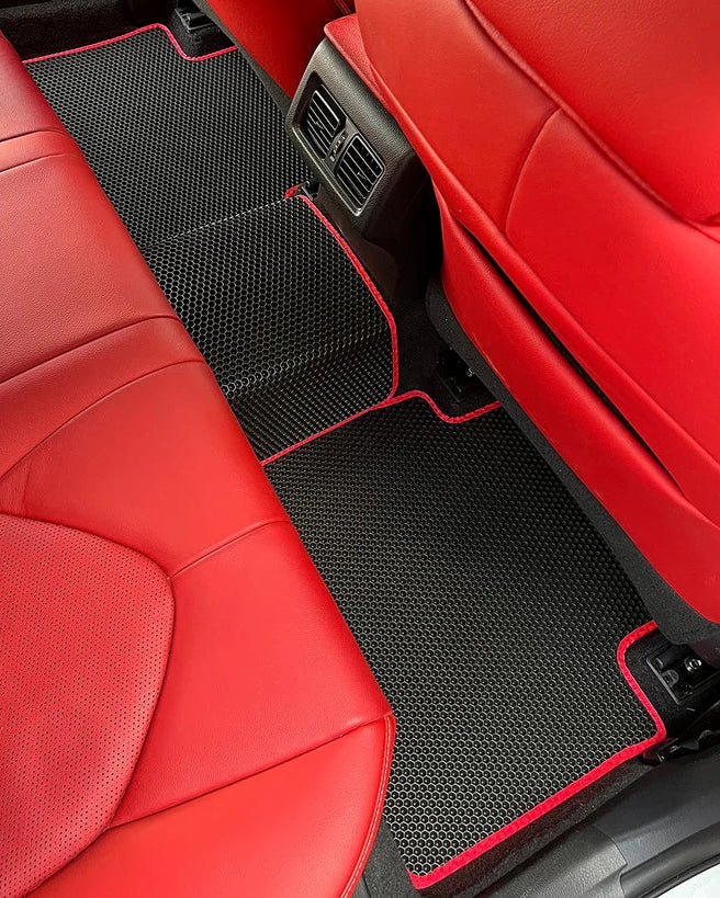 Black EVA rear car mats with red edging, fitted across the rear footwells and centre tunnel for extended floor coverage.